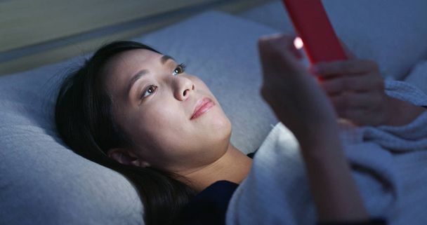 Cep telefonu ve geceleri yatakta yatarken kadın İzle - Fotoğraf, Görsel