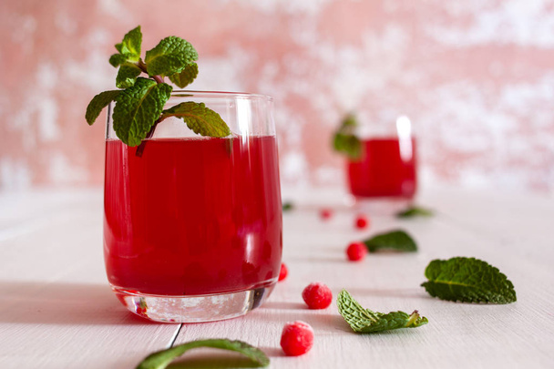 On the table is the juice of viburnum berries with mint and ice - Foto, imagen