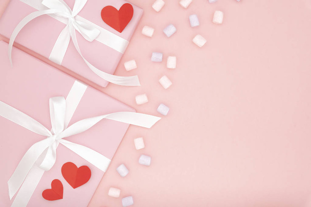 Día de San Valentín, concepto de amor con espacio de copia. Simular marco con regalo o caja de regalo decorado pequeño corazón, dulce postre multi - malvavisco de colores, sobre fondo de papel de coral. Piso tendido, vista superior
 - Foto, imagen