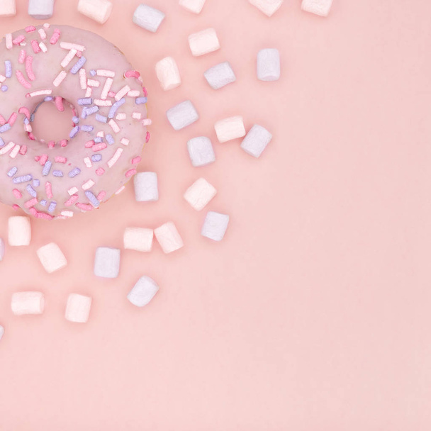 Donut and marshmallow sweet dessert with colorful sprinkles flat lay on pastel coral paper background. Doughnut minimal concept. Copy space - Foto, Imagem