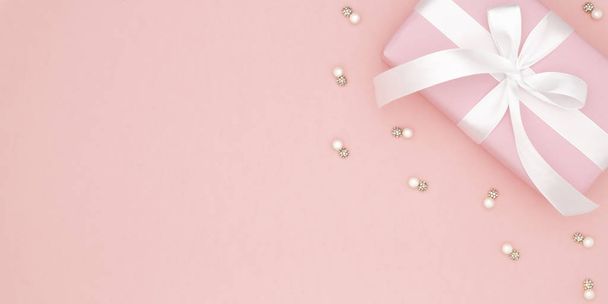 San Valentino o giorno delle donne regalo rosa con fiocco bianco nastro su sfondo di carta corallo. Concetto arredamento amore giorno o compleanno. Piatto. Copia spazio
 - Foto, immagini