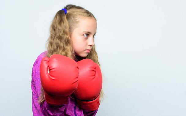 Cute kid with sport boxing gloves. Boxing sport for female. Sport upbringing. Skill of successful leader. Sport upbringing for leader. Girl cute child with red gloves posing on white background - Photo, Image