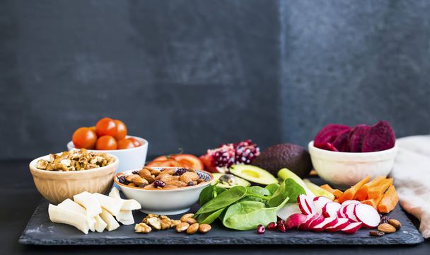 Terveellinen ateria valikoima puhtaita luomuruokaa: vihanneksia, pähkinöitä, avokadoa, manteleita, vihreitä lehtiä, juurikkaita
 - Valokuva, kuva