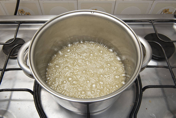 sugar syrup being made in a pan on the stove - Photo, Image