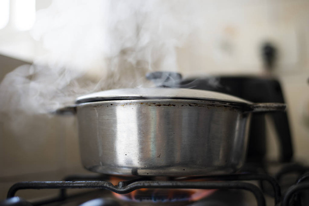 Panela de alumínio no fogão com chama entra e sai fumaça
. - Foto, Imagem