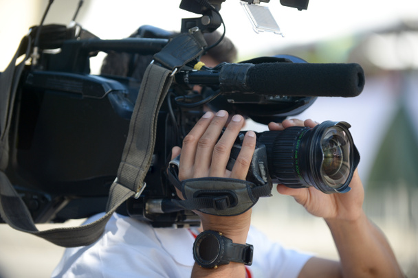 Kameramann hält Kamera während Interview auf der Straße - Foto, Bild