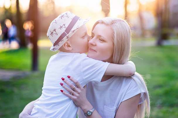 junge Mutter mit ihrem Sohn im Frühlingspark. Muttertag - Foto, Bild