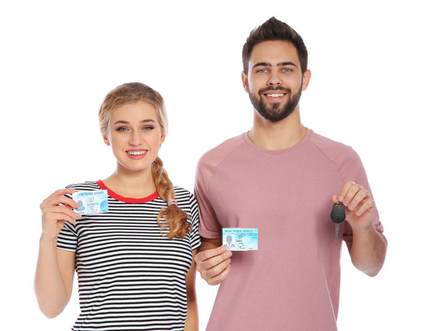 Happy young people with driving licenses on white background - Photo, Image