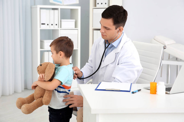 Médecin des enfants examinant un petit patient avec stéthoscope à la maison
 - Photo, image
