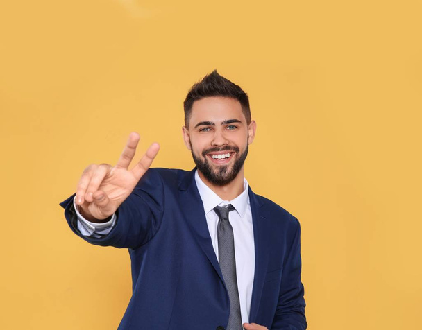 Happy young man celebrating victory on color background - Foto, Bild