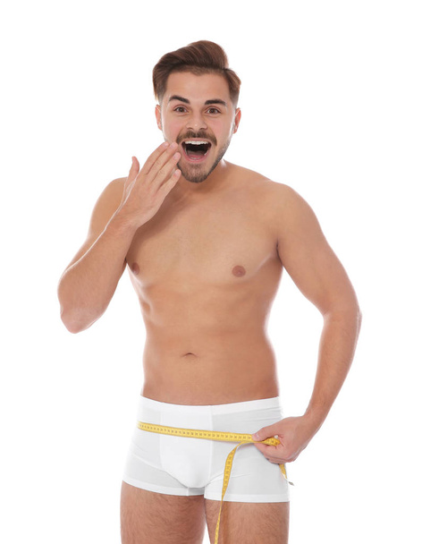 Fit man measuring his waist on white background. Weight loss - Valokuva, kuva