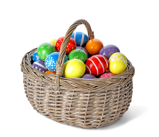 Decorated Easter eggs in wicker basket on white background - Foto, Imagem