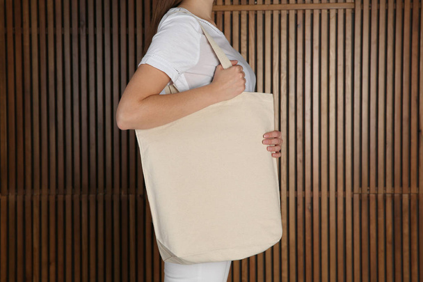 Woman with eco bag on wooden background. Mock up for design - Фото, зображення
