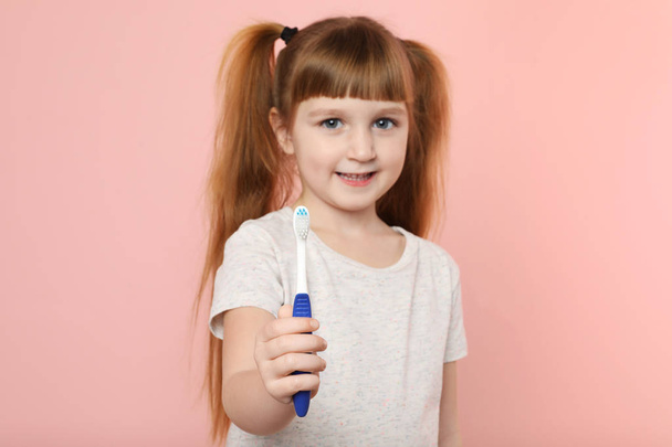 Little girl with toothbrush on color background. Teeth care - Fotoğraf, Görsel