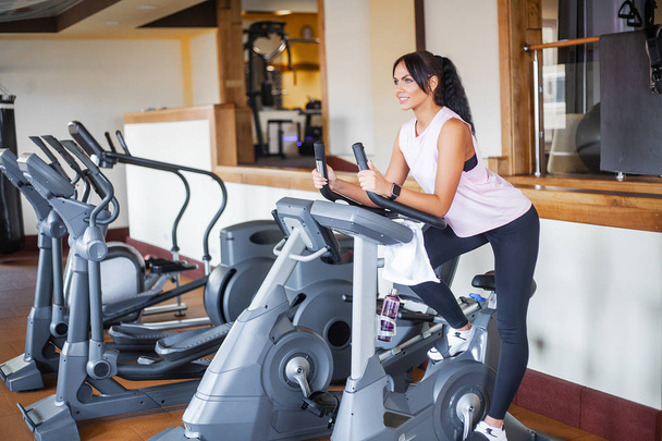 Konzept von Sport und gesunder Lebensweise. Beintraining beim Cardio-Workout auf dem Fahrrad - Foto, Bild