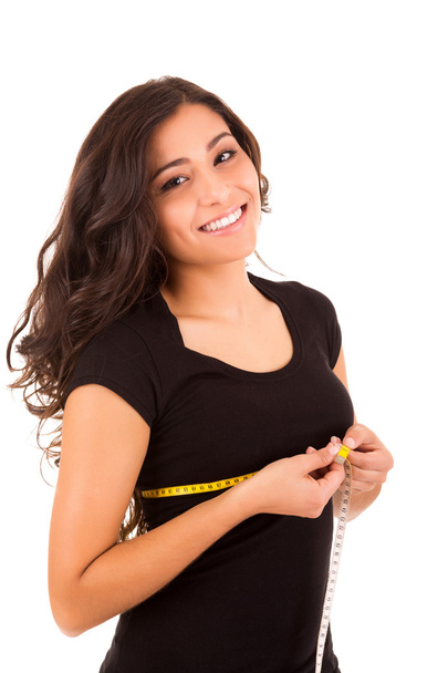 Beautiful slim woman measuring her body with a measuring tape - Photo, Image