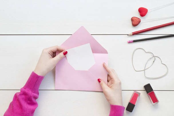 Woman hands holding pink envelope and card.Valentine day concept. - Photo, Image
