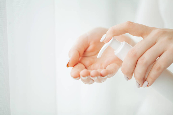 Péče o kůži. Zblízka ženské ruce mrdka Tube, krásná žena rukou s přírodní manikúra nehty použití kosmetických Hand Cream na měkkou hedvábnou zdravou kůži - Fotografie, Obrázek