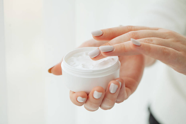 Hand Skin Care. Close Up Of Female Hands Holding Cream Tube, Beautiful Woman Hands With Natural Manicure Nails Applying Cosmetic Hand Cream On Soft Silky Healthy Skin - Photo, Image
