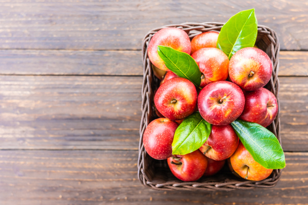 Bir sürü tablo üzerinde kahverengi sepet içinde kırmızı elma meyve - Fotoğraf, Görsel
