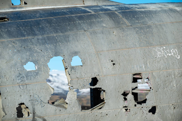 Ongericht bergzicht via de openingen van de verlaten Dc vliegtuig romp op Solheimasandur, IJsland. - Foto, afbeelding