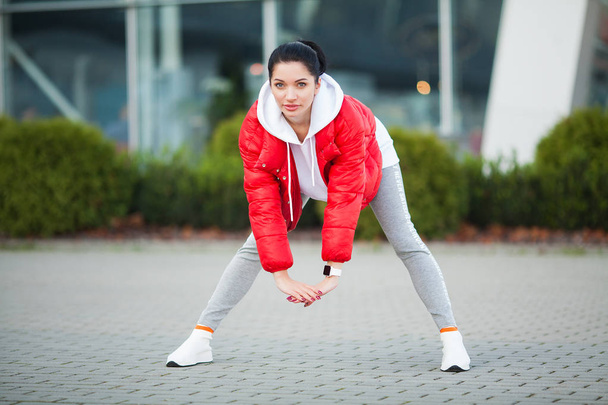 Женщина растягивает тело, делает упражнения на улице
 - Фото, изображение
