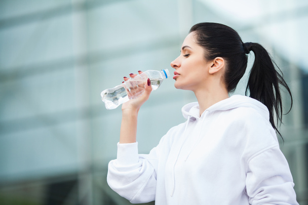 Fitness al aire libre. Mujer bebiendo botella de agua
 - Foto, Imagen