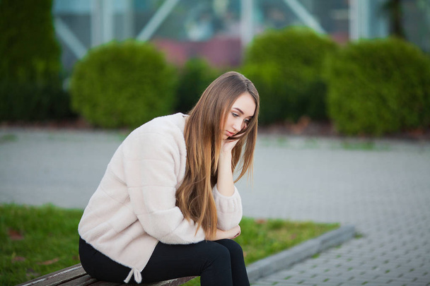 Woman stressed from work while sitting outdoors, press from colleagues - Photo, Image