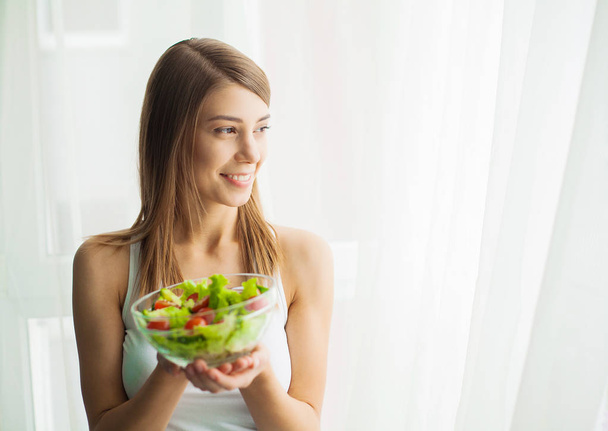 Diet and health. Young woman eating healthy salad after workout - Photo, Image
