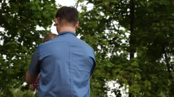 幸せなお父さんをオン彼の娘に彼の手の散歩彼女緑豊かな公園で. - 映像、動画