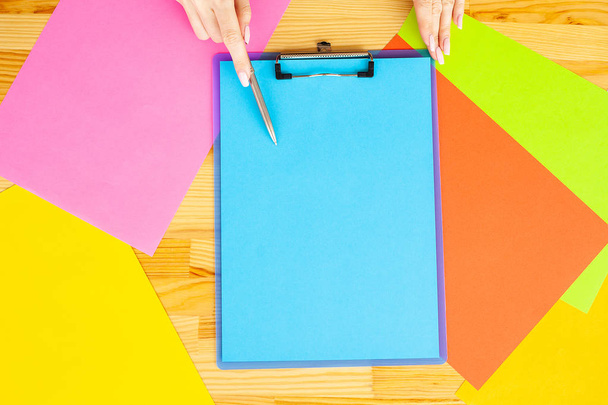 Office Hand Holding kansio sininen väri paperi ja kynä värillinen tausta puinen pöytä. Kopioi tilaa. Tekstipaikka
 - Valokuva, kuva