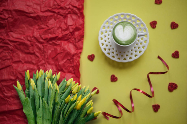 eine Tasse mit einem leckeren und aromatischen Matcha-Latte-Kaffee am Morgen vor festlichem Hintergrund. - Foto, Bild