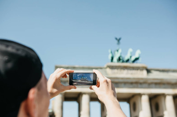 Tourist photographs on a mobile phone the Brandenburg Gate in Berlin in Germany. - Fotografie, Obrázek