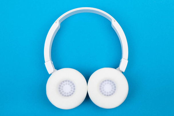 Бездротові білі навушники на синьому фоні. Музична концепція. Навушники на синьому фоні
.  - Фото, зображення