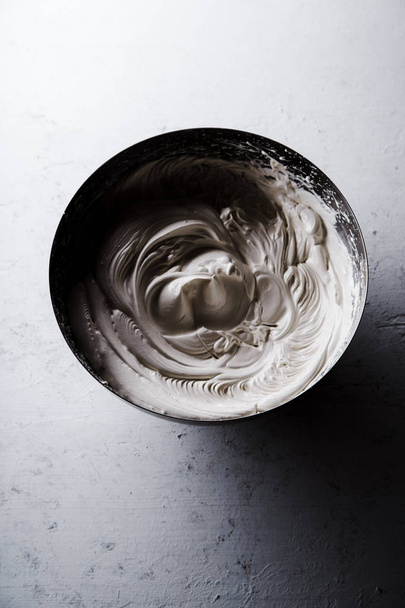 Cuenco metálico con claras de huevo batidas con azúcar, concepto de cocina merengue
 - Foto, Imagen