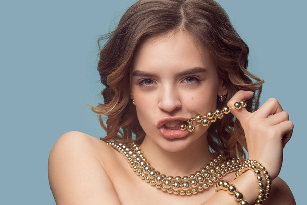 Beautiful young girl in studio with pearl jewelry - earrings, bracelet, necklace. - Foto, Imagen