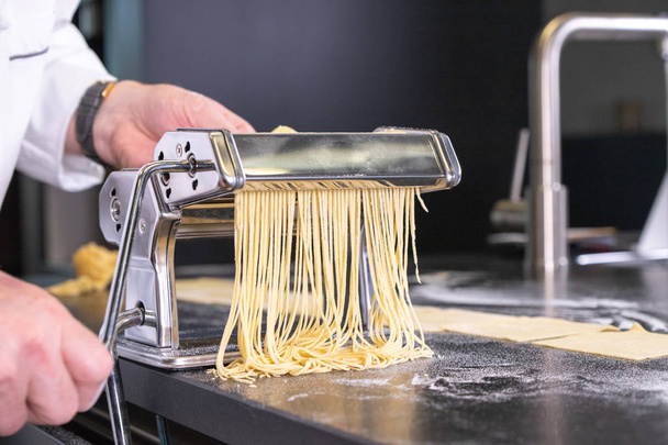 vorming van spaghetti in Pastamachine - Foto, afbeelding