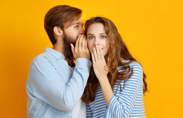 pareja de jóvenes emocionales hombre y mujer sobre fondo amarillo
 - Foto, Imagen
