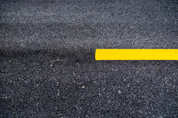 Cerca de la superficie de asfalto de la carretera divide las líneas amarillas
 - Foto, imagen