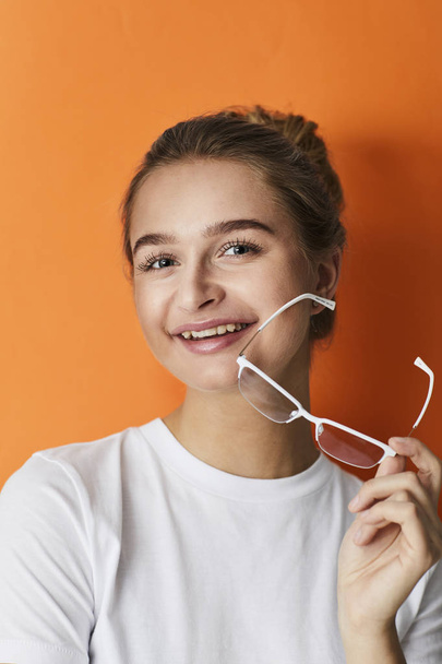 Girl with glasses against orange background - Fotografie, Obrázek