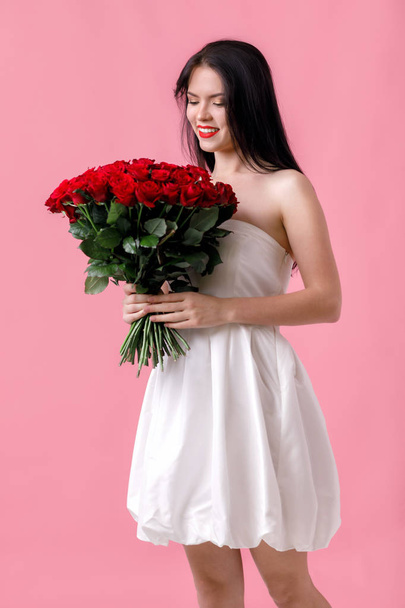 赤いバラの大きな花束と美しい若い女性 - 写真・画像