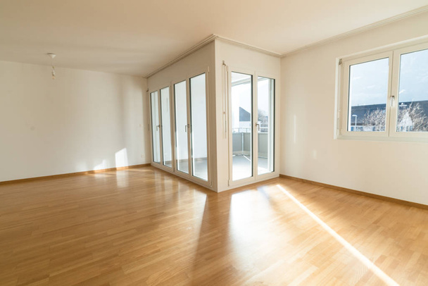 luminoso salón nuevo en un apartamento vacío con puertas francesas y suelos de parquet de madera
 - Foto, imagen