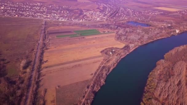 Langzame drone-vlucht over blauwe rivier en landbouwgronden. Dnjestr river, Moldavië Republiek. 4 k birds eye view - Video