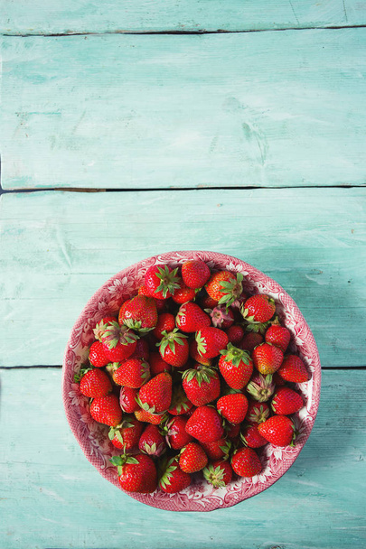 top view of fresh ripe strawberries on turquoise surface - 写真・画像