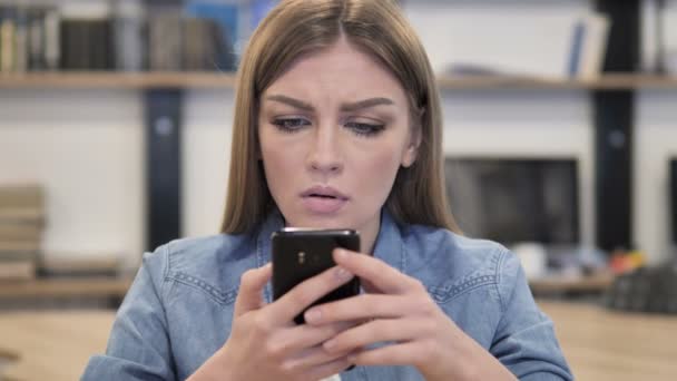 Kreativní žena reaguje na ztrátu při používání smartphonu - Záběry, video