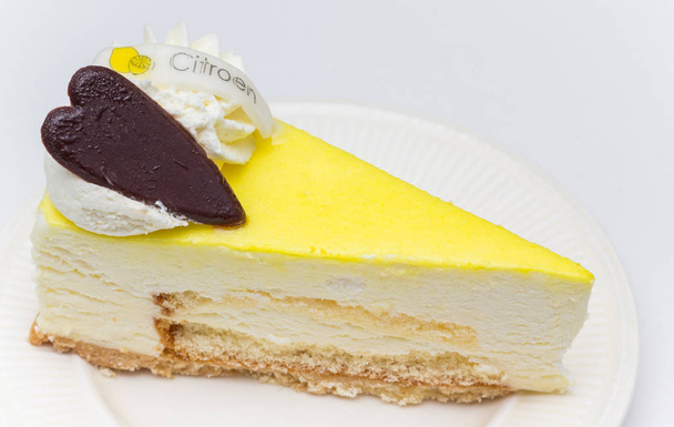 Bolo de queijo limão com coração de chocolate servido em um prato branco, rotulado com a palavra holandesa para limão
 - Foto, Imagem