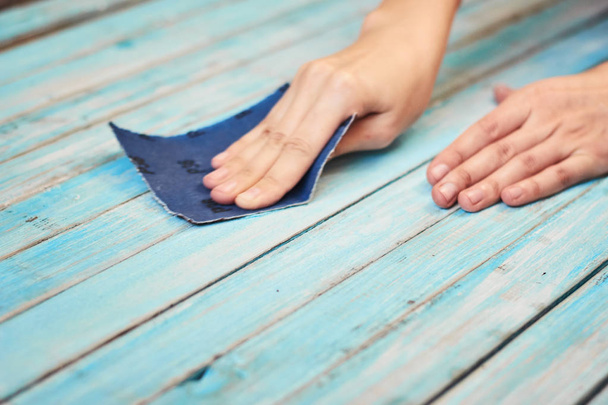Hands polishing wooden boards with a sandpaper - Photo, Image