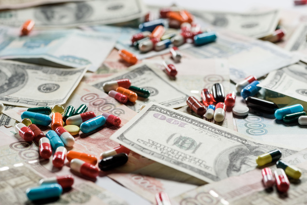 close-up de comprimidos multicoloridos no fundo do dinheiro
 - Foto, Imagem