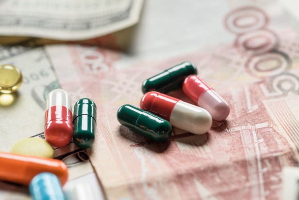 close up of different pills on cash background - Zdjęcie, obraz