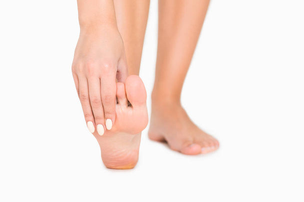 Frau berührt ihre weichen Fußsohlen nach Schönheitsoperationen - Foto, Bild